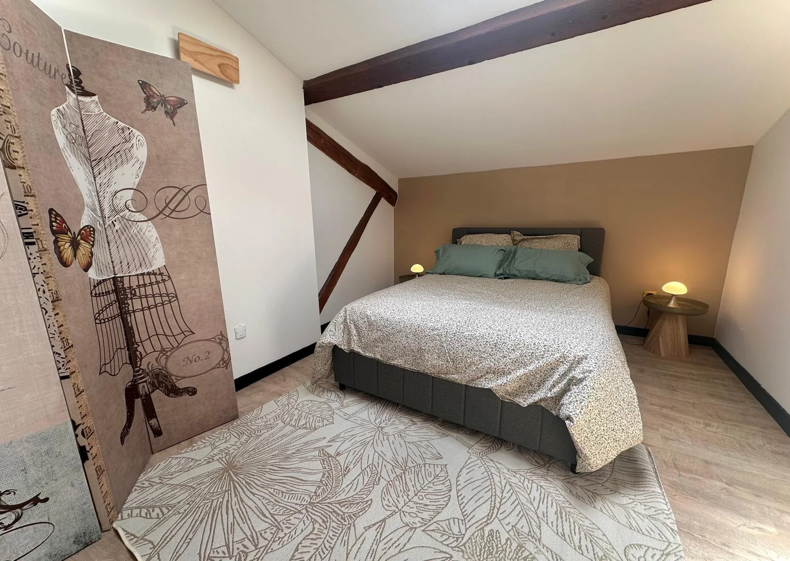 Chambre avec lit double et poutres apparentes